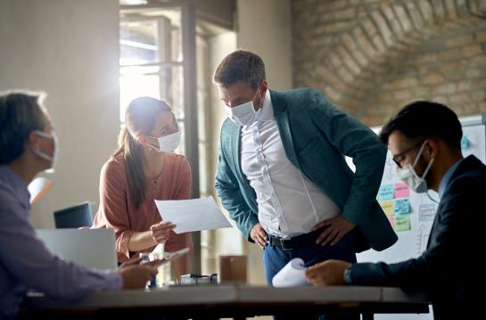 Business,Colleagues,With,Protective,Face,Masks,Analyzing,Reports,On,A