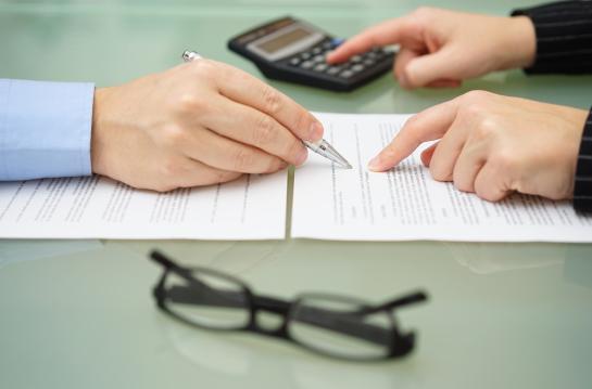 Businesswoman,Is,Reviewing,Document,With,Tax,Consultant,And,Making,Calculations