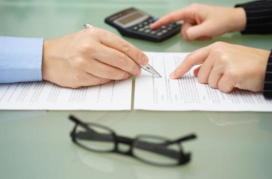 Businesswoman,Is,Reviewing,Document,With,Tax,Consultant,And,Making,Calculations